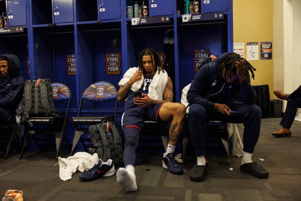 UConn guard Solo Ball (1) and UConn guard Malachi Smith (0) sit in the locker room after losing to Michigan, 69-63, in the NCAA title game on April 6, 2026, at Lucas Oil Stadium in Indianapolis. (Armando L. Sanchez/Chicago Tribune)