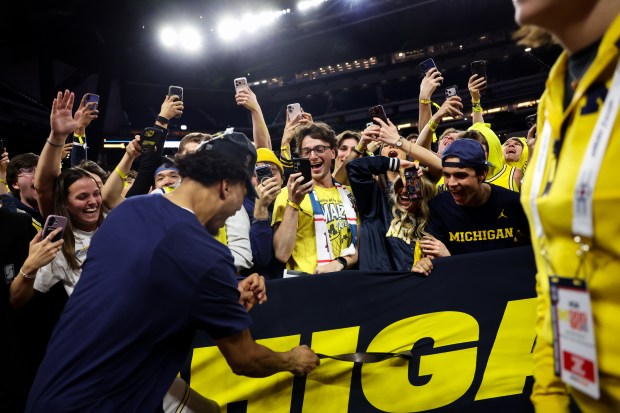 Michigan forward Yaxel Lendeborg (23) celebrates with fans after defeating UConn, 69-63, in the NCAA title game on April 6, 2026, at Lucas Oil Stadium in Indianapolis. (Armando L. Sanchez/Chicago Tribune)