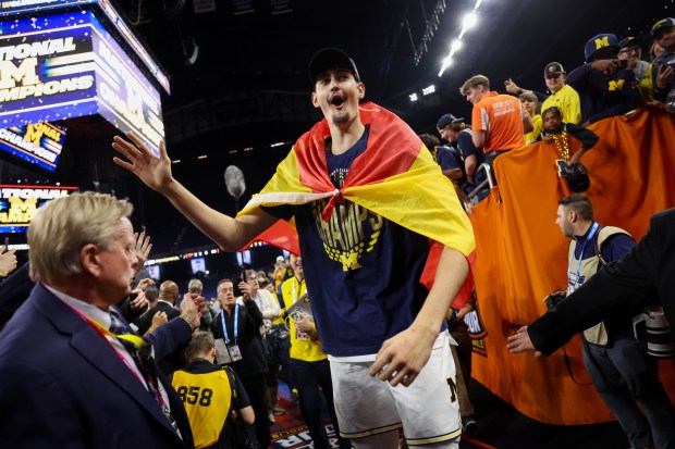 Michigan center Aday Mara (15) celebrates with fans after defeating UConn, 69-63, in the NCAA title game on April 6, 2026, at Lucas Oil Stadium in Indianapolis. (Armando L. Sanchez/Chicago Tribune)