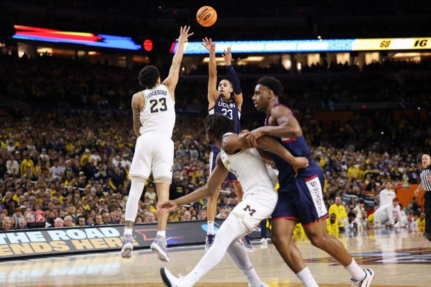 Michigan forward Yaxel Lendeborg (23) guards UConn forward Jayden Ross (23) while he goes up for a 3-point shot during the second half of the NCAA title game between UConn and Michigan April 6, 2026, at Lucas Oil Stadium in Indianapolis. (Armando L. Sanchez/Chicago Tribune)