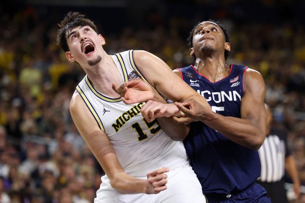 Michigan center Aday Mara (15) and UConn forward Tarris Reed Jr. (5) fight for a rebound during the second half of the NCAA title game between UConn and Michigan April 6, 2026, at Lucas Oil Stadium in Indianapolis. (Armando L. Sanchez/Chicago Tribune)