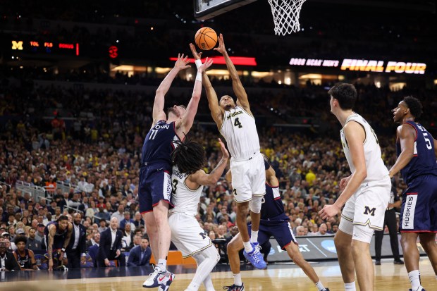 UConn forward Alex Karaban (11) and Michigan guard Nimari Burnett (4) go up for a rebound during the second half of the NCAA title game between UConn and Michigan April 6, 2026, at Lucas Oil Stadium in Indianapolis. (Armando L. Sanchez/Chicago Tribune)