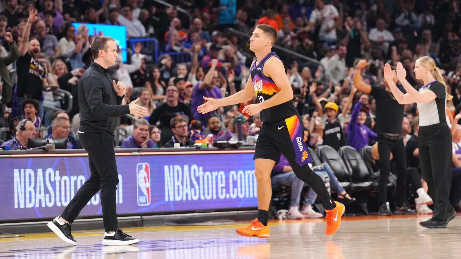 Phoenix Suns guard Collin Gillespie (12) slaps hands with head coach Jordan Ott after making a buzzer beater against the Charlotte Hornets during the first half at Mortgage Matchup Center.