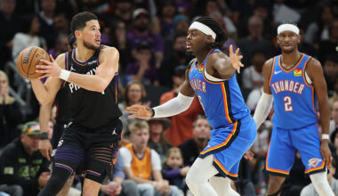 PHOENIX, ARIZONA - JANUARY 04: Devin Booker #1 of the Phoenix Suns looks to pass around Luguentz Dort #5 of the Oklahoma City Thunder during the second half of the NBA game at Mortgage Matchup Center on January 04, 2026 in Phoenix, Arizona. The Suns defeated the Thunder 108-105. NOTE TO USER: User expressly acknowledges and agrees that, by downloading and or using this photograph, user is consenting to the terms and conditions of the Getty Images License Agreement. (Photo by Christian Petersen/Getty Images)