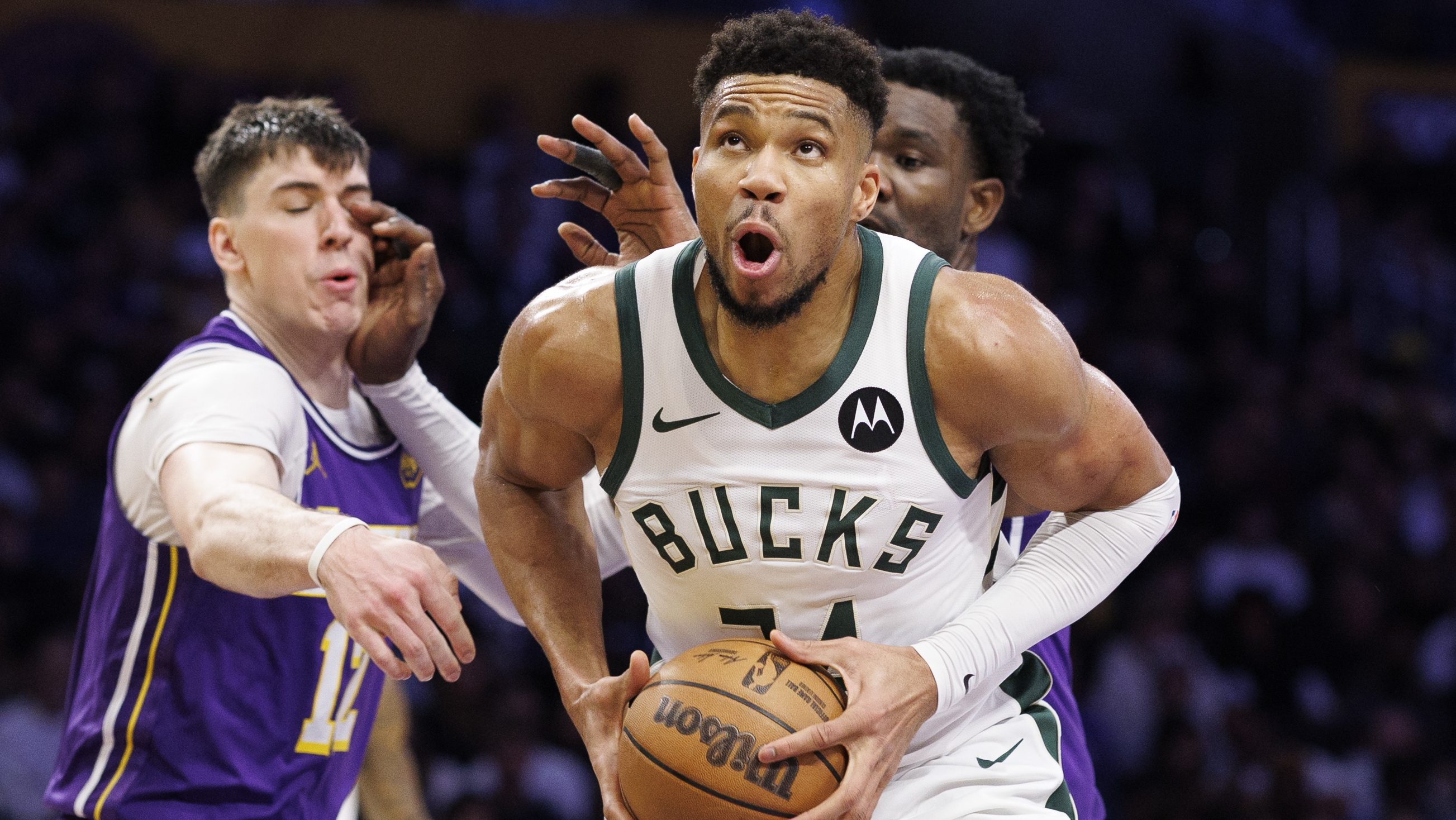 Milwaukee Bucks forward Giannis Antetokounmpo (34) puts up a shot under the basket in front of Los Angeles Lakers forward Jake LaRavia (12)