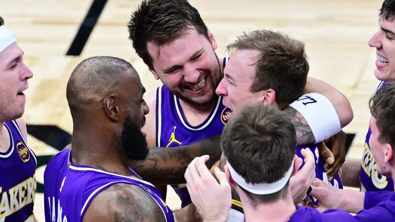 Luke Kennard #10 of the Los Angeles Lakers celebrates with Deandre Ayton #5, Austin Reaves #15, LeBron James #23, Luka Doncic #77, and Jake LaRavia #12 after scoring a go-ahead three-point-basket in the fourth quarter against the Orlando Magic.