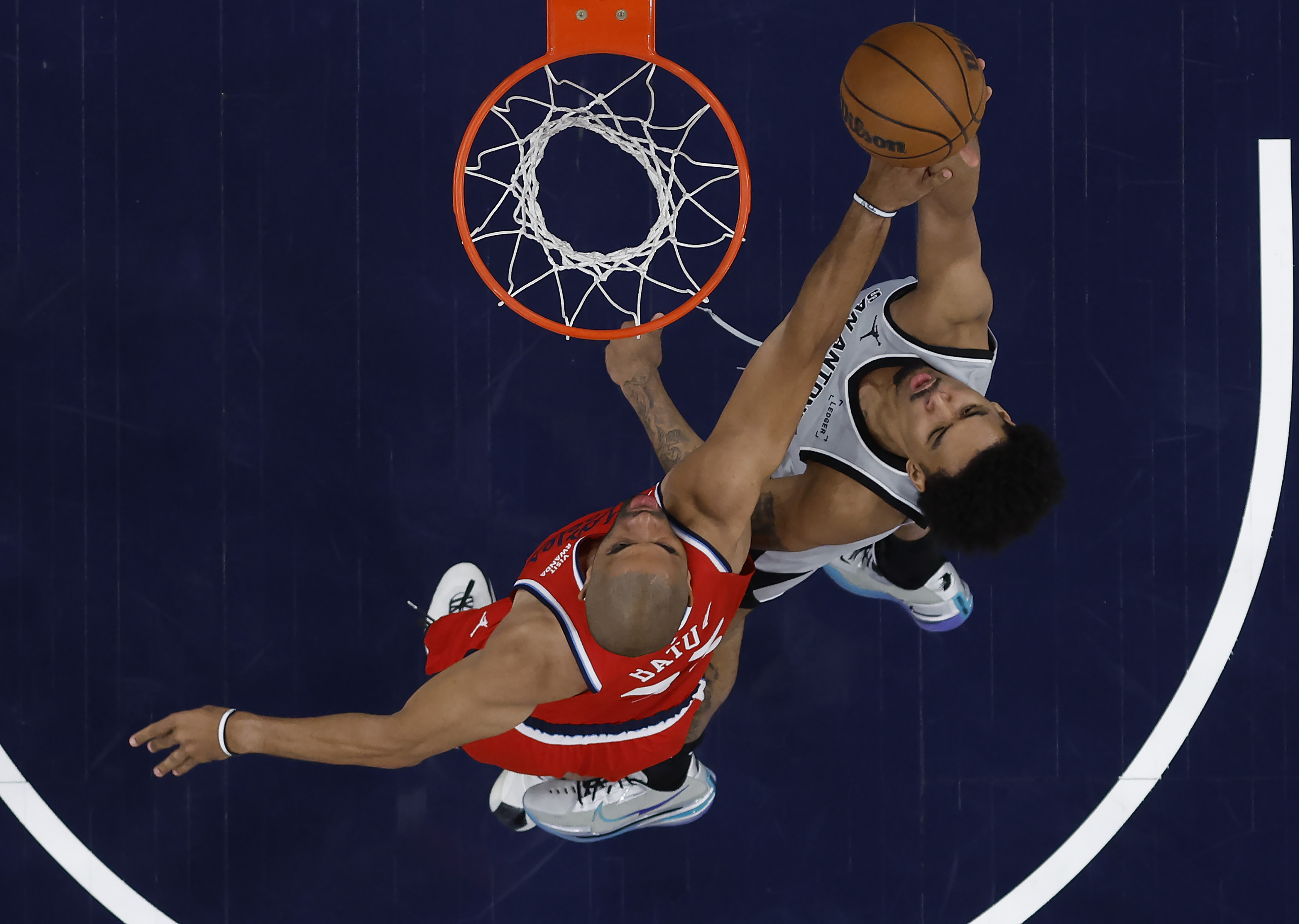 The San Antonio Spurs’ Dylan Harper, right, shoots as Clippers...