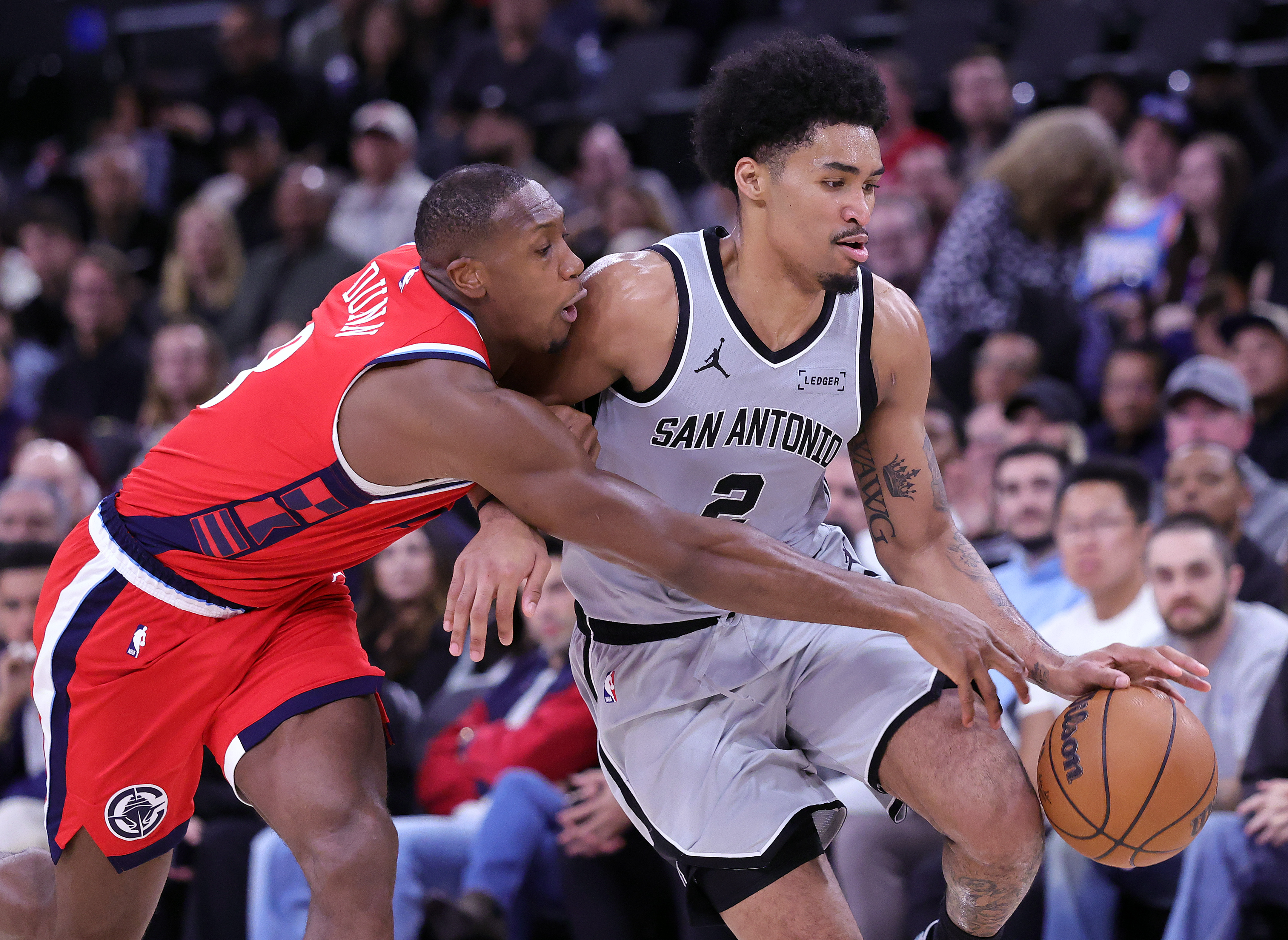 The San Antonio Spurs’ Dylan Harper, right, handles the ball...