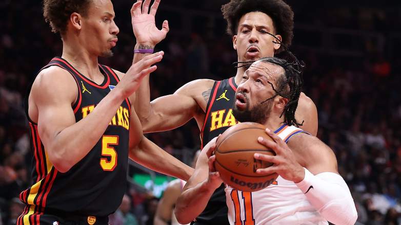 Jalen Brunson #11 of the New York Knicks ldrives against Dyson Daniels #5 and Jalen Johnson #1 of the Atlanta Hawks
