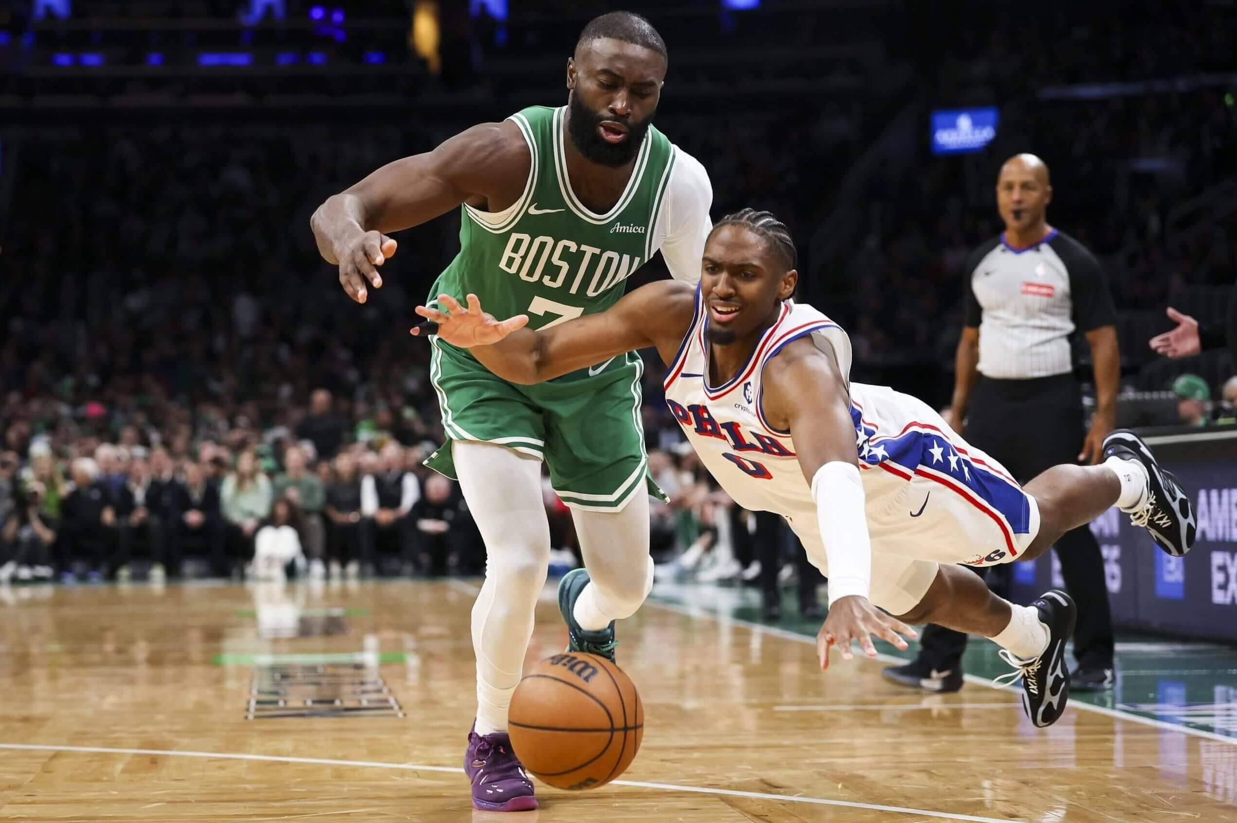 Philadelphia's Tyrese Maxey dives for a loose ball in front of Boston's Jaylen Brown.