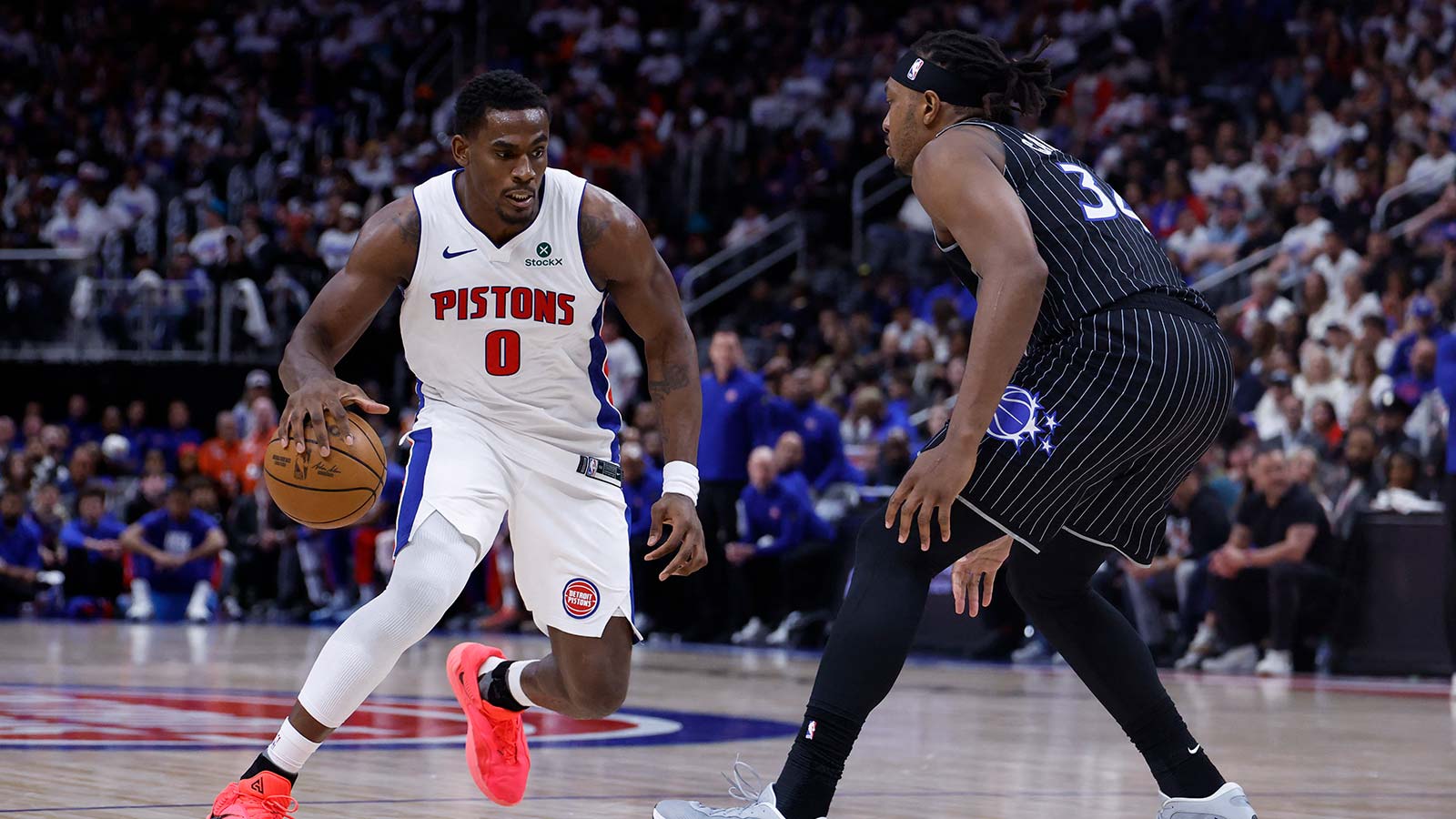 Detroit Pistons center Jalen Duren (0) dribbles defended by Orlando Magic center Wendell Carter Jr. (34) in the second half during the 2026 NBA Playoffs at Little Caesars Arena. 