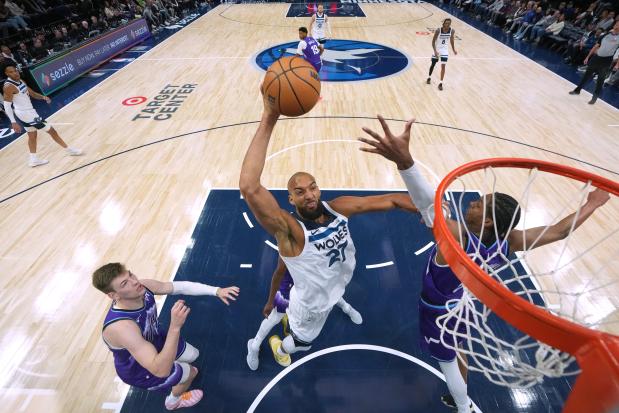 Minnesota Timberwolves center Rudy Gobert (27) dunks while defended by Utah Jazz forwards Kyle Filipowski (22), left, and Cody Williams (5), right, during the first half of an NBA basketball game, Wednesday, March 18, 2026, in Minneapolis. (AP Photo/Abbie Parr)