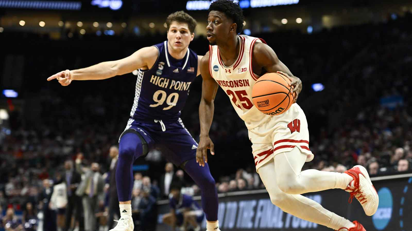 Wisconsin Badgers guard John Blackwell (25) drives to the basket against High Point Panthers guard Chase Johnston (99) during the second half of a first round game of the men's 2026 NCAA Tournament at Moda Center.