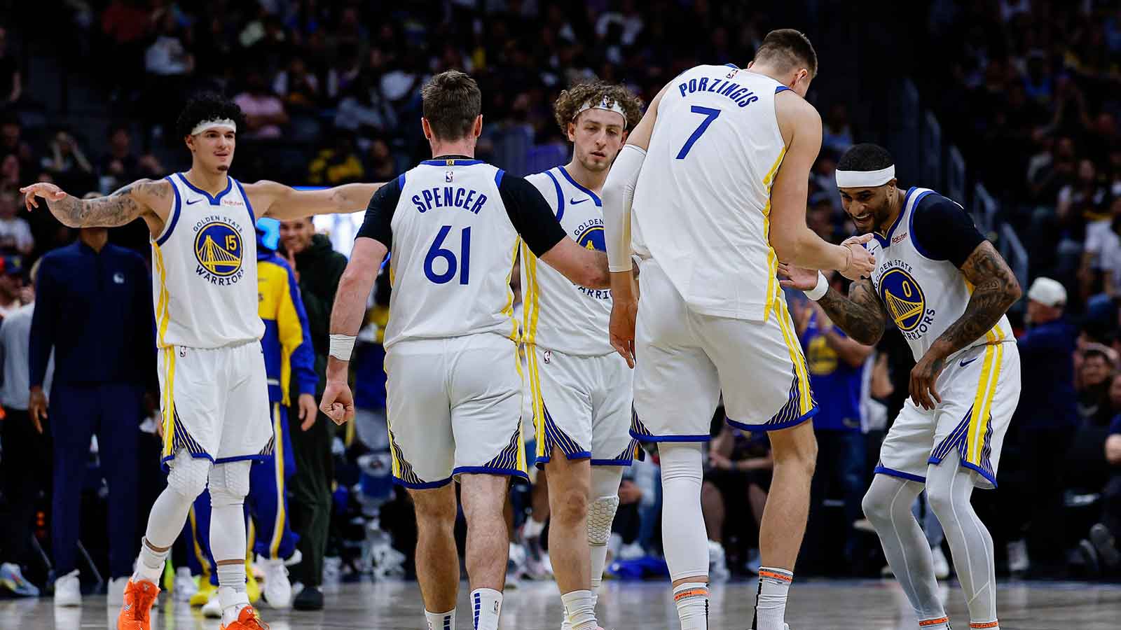 Golden State Warriors center Kristaps Porzingis (7) reacts with guard Gary Payton II (0) and guard Brandin Podziemski (2) and guard Pat Spencer (61) and forward Gui Santos (15) after a play in the second quarter against the Denver Nuggets at Ball Arena.