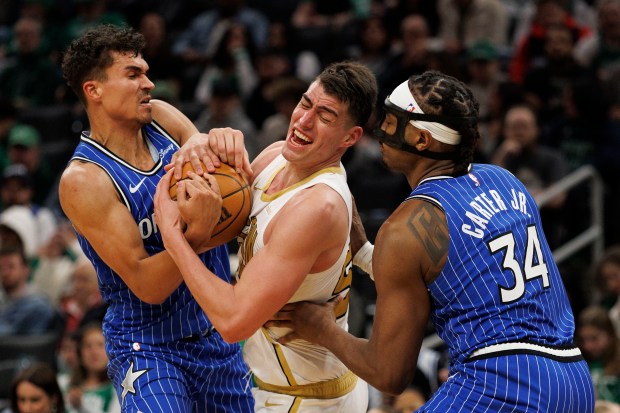 Boston Celtics center Luka Garza center, battles with Orlando Magic forward Tristan da Silva left, and Orlando Magic center Wendell Carter Jr. right, for control of the ball during the second half against the Orlando Magic at the TD Garden on April 12, 2026. (CJ Gunther/Boston Herald)