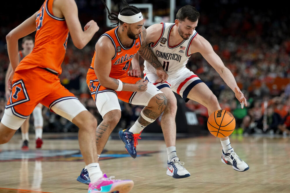 Illinois guard Kylan Boswell (4) and UConn forward Alex Karaban (11) battle for the ball during the first half of an NCAA college basketball tournament semifinal game. (Abbie Parr/AP)
