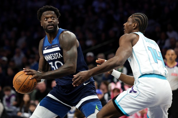 Minnesota Timberwolves forward Julius Randle, left, looks to shoot as Charlotte Hornets forward Moussa Diabate (14) defends during the first half of an NBA basketball game, Sunday, April 5, 2026, in Minneapolis. (AP Photo/Matt Krohn)