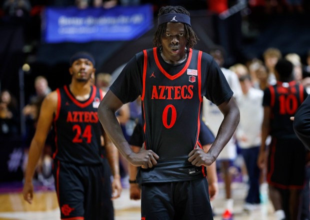 SDSU's Taj DeGourville and Magoon Gwath walk off the court after a loss to Utah State in the Mountain West tournament final in Las Vegas on March 14. (K.C. Alfred / The San Diego Union-Tribune)