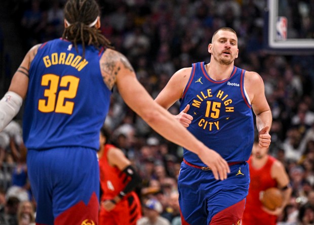 Nikola Jokic (15) of the Denver Nuggets jogs towards the outstretched hand of Aaron Gordon (32) after scoring against the Portland Trail Blazers during the third quarter at Ball Arena in Denver on Sunday, March 22, 2026. (Photo by AAron Ontiveroz/The Denver Post)