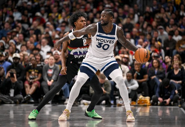 Julius Randle (30) of the Minnesota Timberwolves backs down Peyton Watson (8) of the Denver Nuggets during the third quarter at Ball Arena in Denver, Colorado on Thursday, Dec. 25, 2025. (Photo by AAron Ontiveroz/The Denver Post)