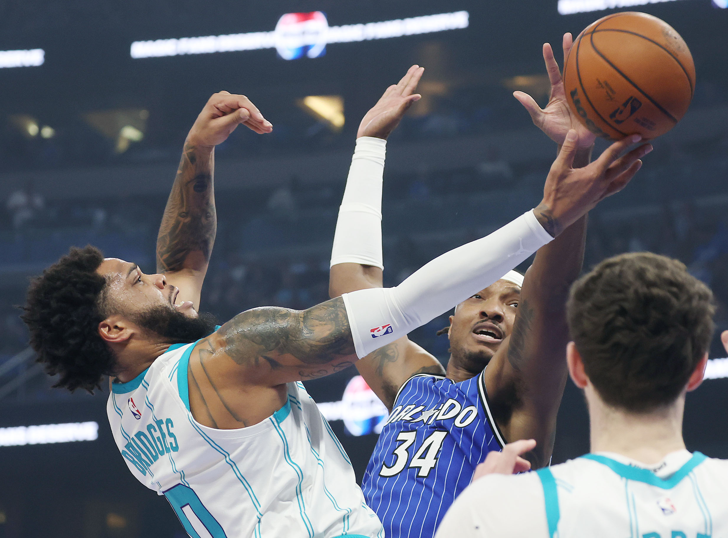Charlotte forward Miles Bridges (0) shoots past Orlando center Wendell...