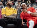 Toronto Raptors' Brandon Ingram (left) and Scottie Barnes share a laugh on the bench during a game.
