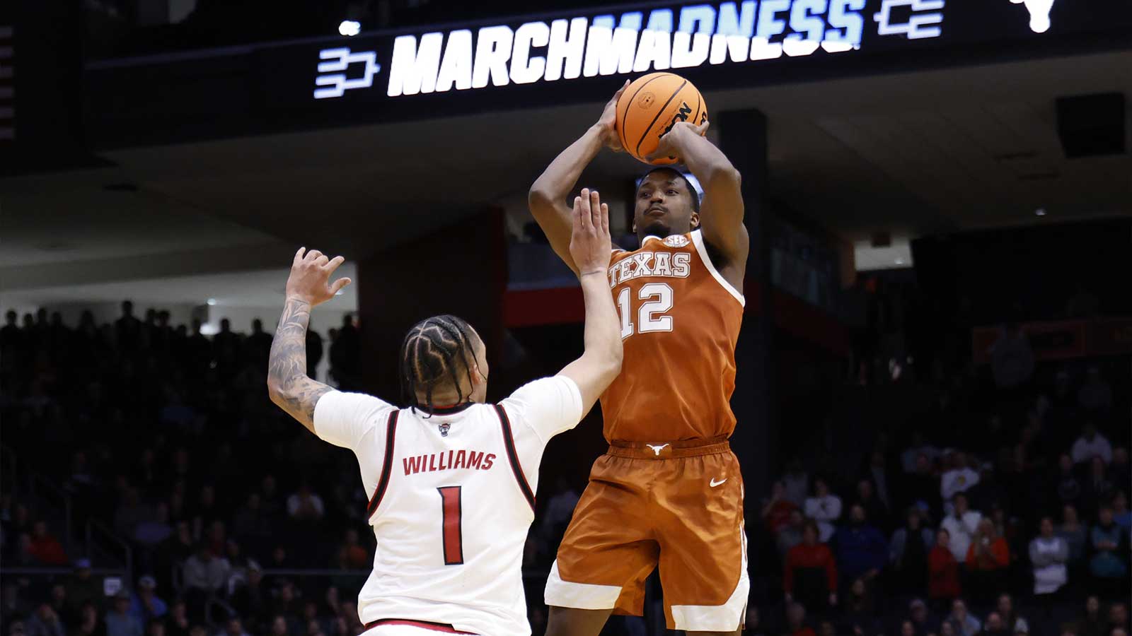 Texas Longhorns guard Tramon Mark (12) shoots the ball over NC State Wolfpack forward Darrion Williams (1) in the second half during a first four game of the men's 2026 NCAA Tournament at University of Dayton Arena. 