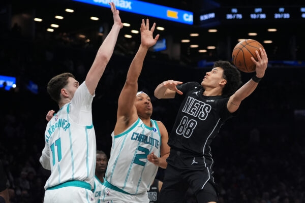 Brooklyn Nets' Nolan Traore (88) shoots over Charlotte Hornets' Grant Williams (2) and Ryan Kalkbrenner (11) during the second half of an NBA basketball game Tuesday, March 31, 2026, in New York. (AP Photo/Frank Franklin II)