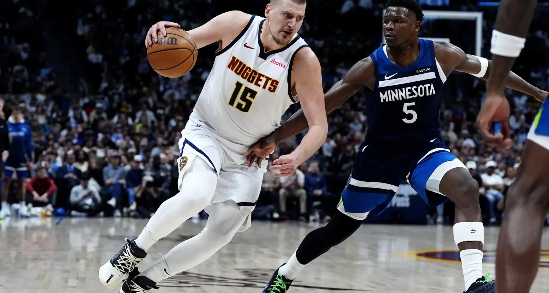 Minnesota Timberwolves guard Anthony Edwards (5) defends Denver Nuggets center Nikola Jokic (15) in the second half at Ball Arena.