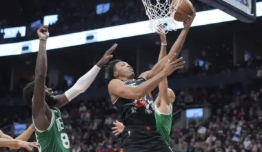 Dec 7, 2025; Toronto, Ontario, CAN; Toronto Raptors guard Scottie Barnes (4) goes up to make a basket against Boston Celtics center Neemias Queta (88) and guard Derrick White (9) during the second half at Scotiabank Arena. Mandatory Credit: John E. Sokolowski-Imagn Images