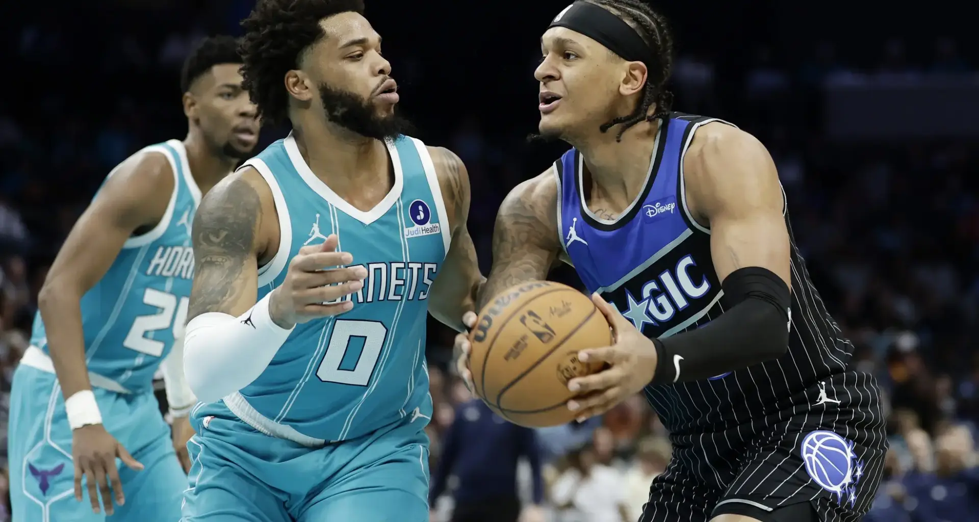 Mar 19, 2026; Charlotte, North Carolina, USA; Orlando Magic forward Paolo Banchero (5) tries to drive to the basket past Charlotte Hornets forward Miles Bridges (0) during the third quarter at Spectrum Center. Mandatory Credit: Brian Westerholt-Imagn Images