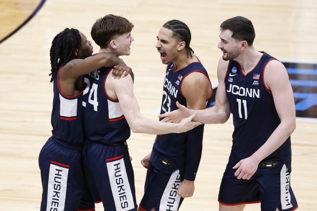 UConn Huskies guard Braylon Mullins (24) celebrates with teammates after scoring the game winning basket in the second half against the Duke Blue Devils during an Elite Eight game of the East Regional of the men's 2026 NCAA Tournament at Capital One Arena. 