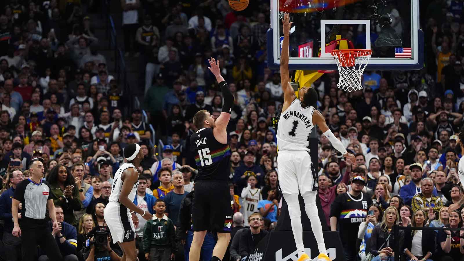 Denver Nuggets center Nikola Jokic (15) shoots the ball over San Antonio Spurs forward Victor Wembanyama (1) in overtime at Ball Arena.