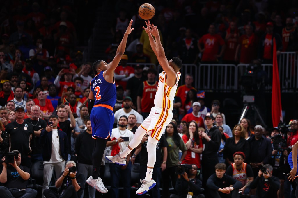 Basketball players CJ McCollum and Miles McBride jump for the ball during an NBA Playoffs game.