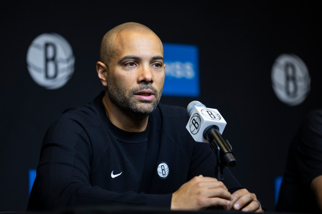 Jordi Fernandez speaking at a press conference with a microphone in front of him.