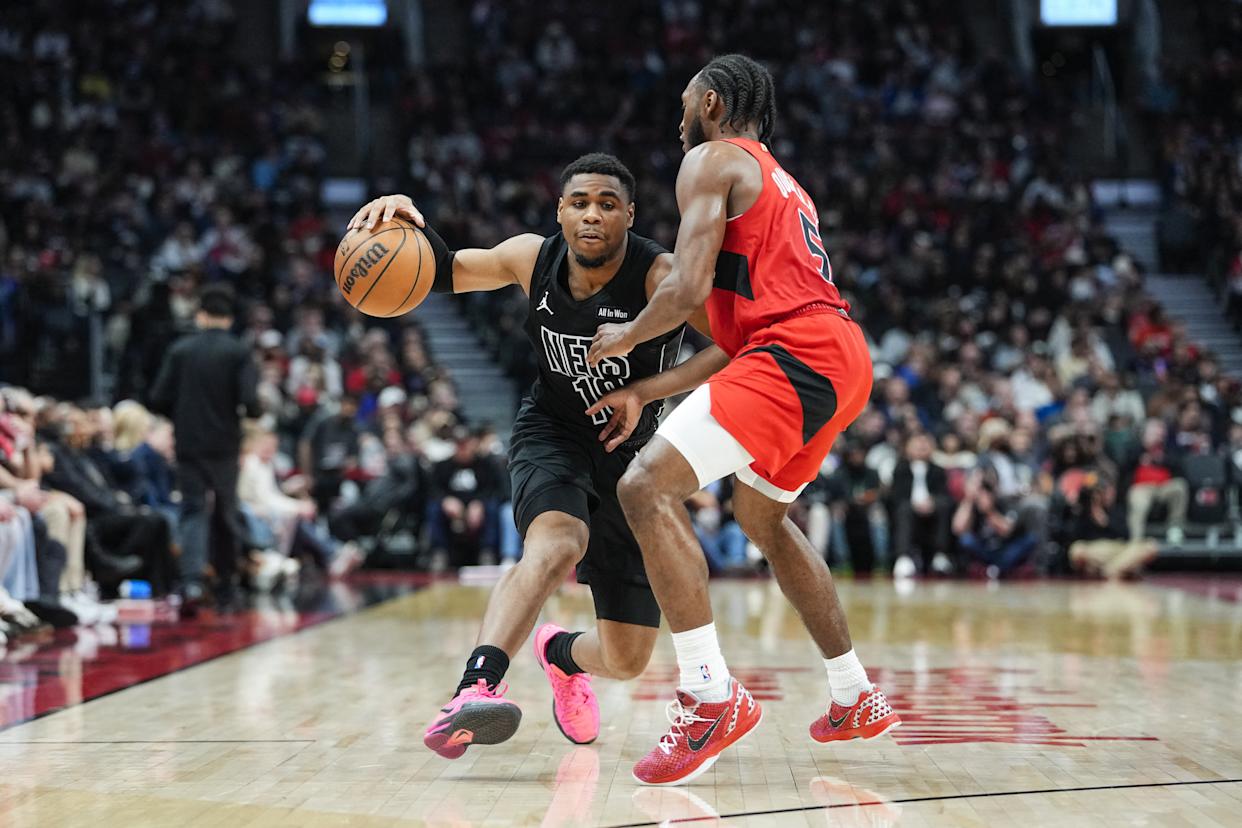 Malachi Smith of the Brooklyn Nets dribbles against Immanuel Quickley of the Toronto Raptors.