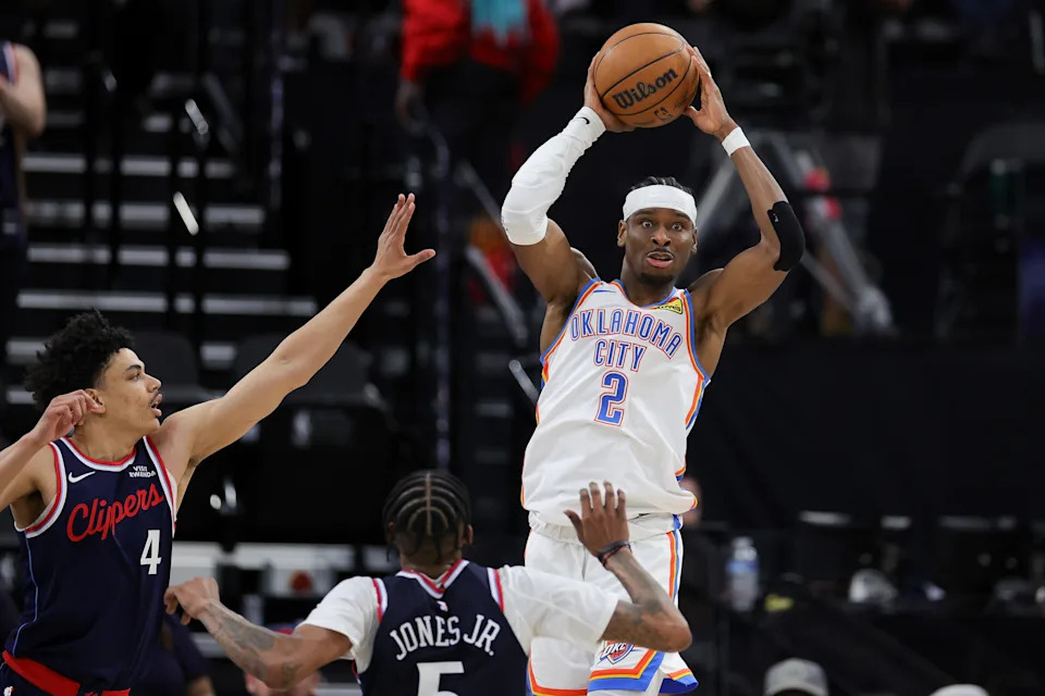 INGLEWOOD, CALIFORNIA - APRIL 08: Shai Gilgeous-Alexander #2 of the Oklahoma City Thunder passes the ball over Kobe Sanders #4 and Derrick Jones Jr. #5 of the Los Angeles Clippers during the first half of an NBA game at Intuit Dome on April 08, 2026 in Inglewood, California. NOTE TO USER: User expressly acknowledges and agrees that, by downloading and or using this photograph, User is consenting to the terms and conditions of the Getty Images License Agreement. (Photo by Ryan Sirius Sun/Getty Images)