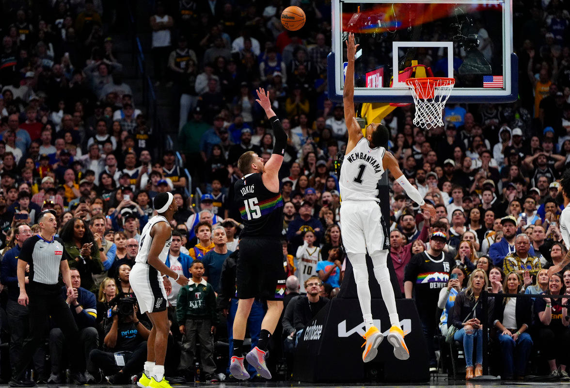Denver Nuggets star Nikola Jokic goes for high arching shot against Victor WembanyamaRon Chenoy-Imagn Images