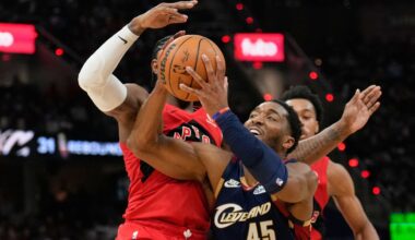 Cleveland Cavaliers guard Donovan Mitchell (45) drives past Toronto Raptors forward RJ Barrett, left, in the second half in Game 2 of a first-round NBA basketball playoffs series in Cleveland, Monday, April 20, 2026. (AP Photo/Sue Ogrocki)
