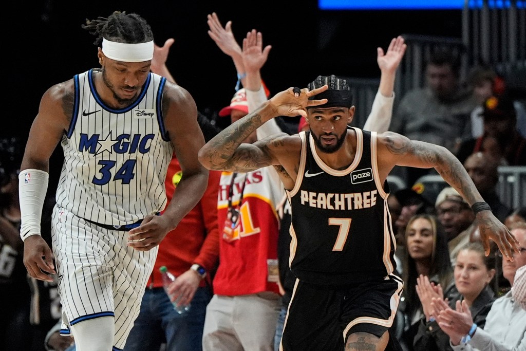 Atlanta Hawks guard Nickeil Alexander-Walker (7) celebrates a three-point shot as Orlando Magic player Wendell Carter Jr. (34) looks on.