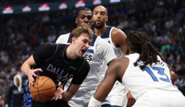 Cooper Flagg of the Dallas Mavericks drives against Ayo Dosunmu and Naz Reid of the Minnesota Timberwolves at American Airlines Center.