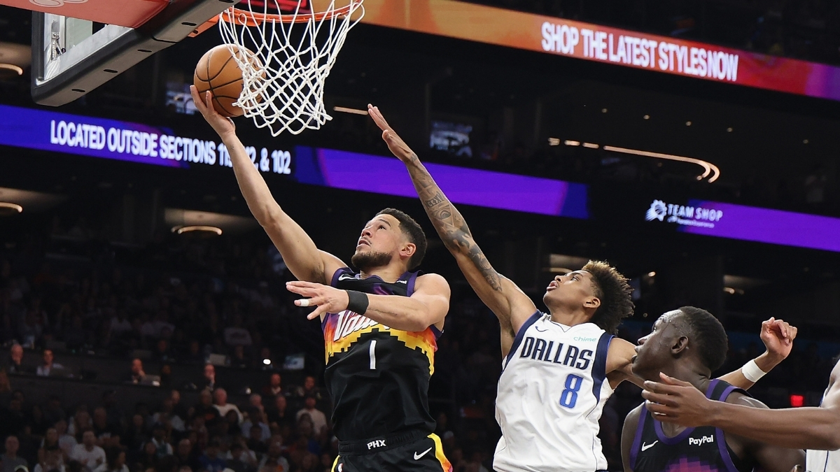 Devin Booker #1 of the Phoenix Suns drives for a layup against AJ Johnson #8 of the Dallas Mavericks during the first half in Phoenix.