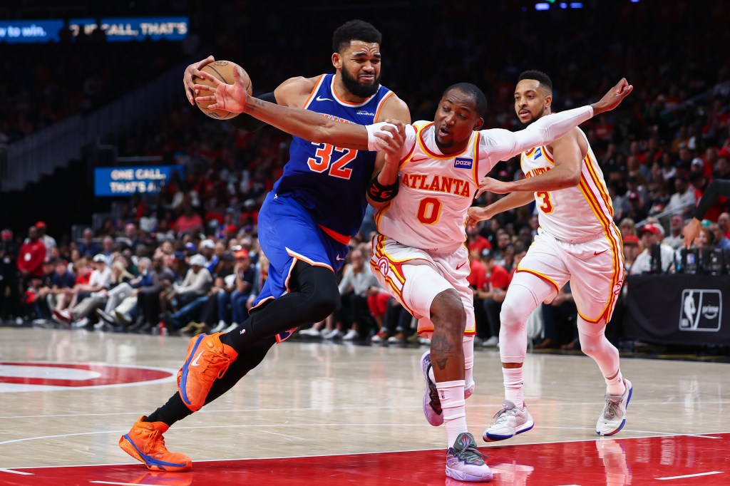 Karl-Anthony Towns (32) of the New York Knicks drives to the basket against Jonathan Kuminga (0) of the Atlanta Hawks during an NBA playoffs game.
