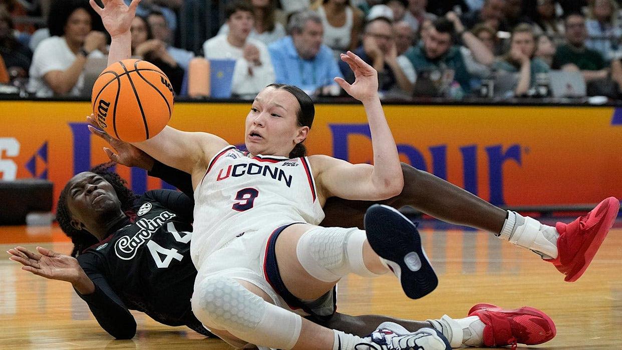 South Carolina guard Agot Makeer and UConn guard Kayleigh Heckel scrambling for the ball during a basketball game