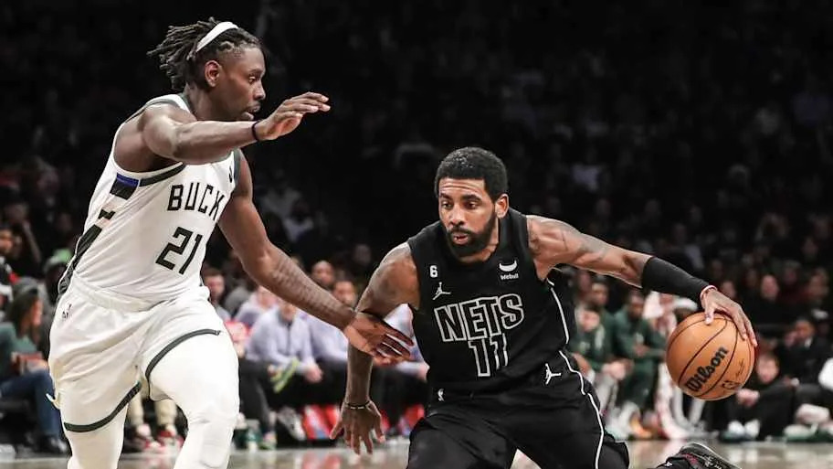 Brooklyn Nets guard Kyrie Irving (11) drives past Milwaukee Bucks guard Jrue Holiday (21). Credit: Wendell Cruz-Imagn Images