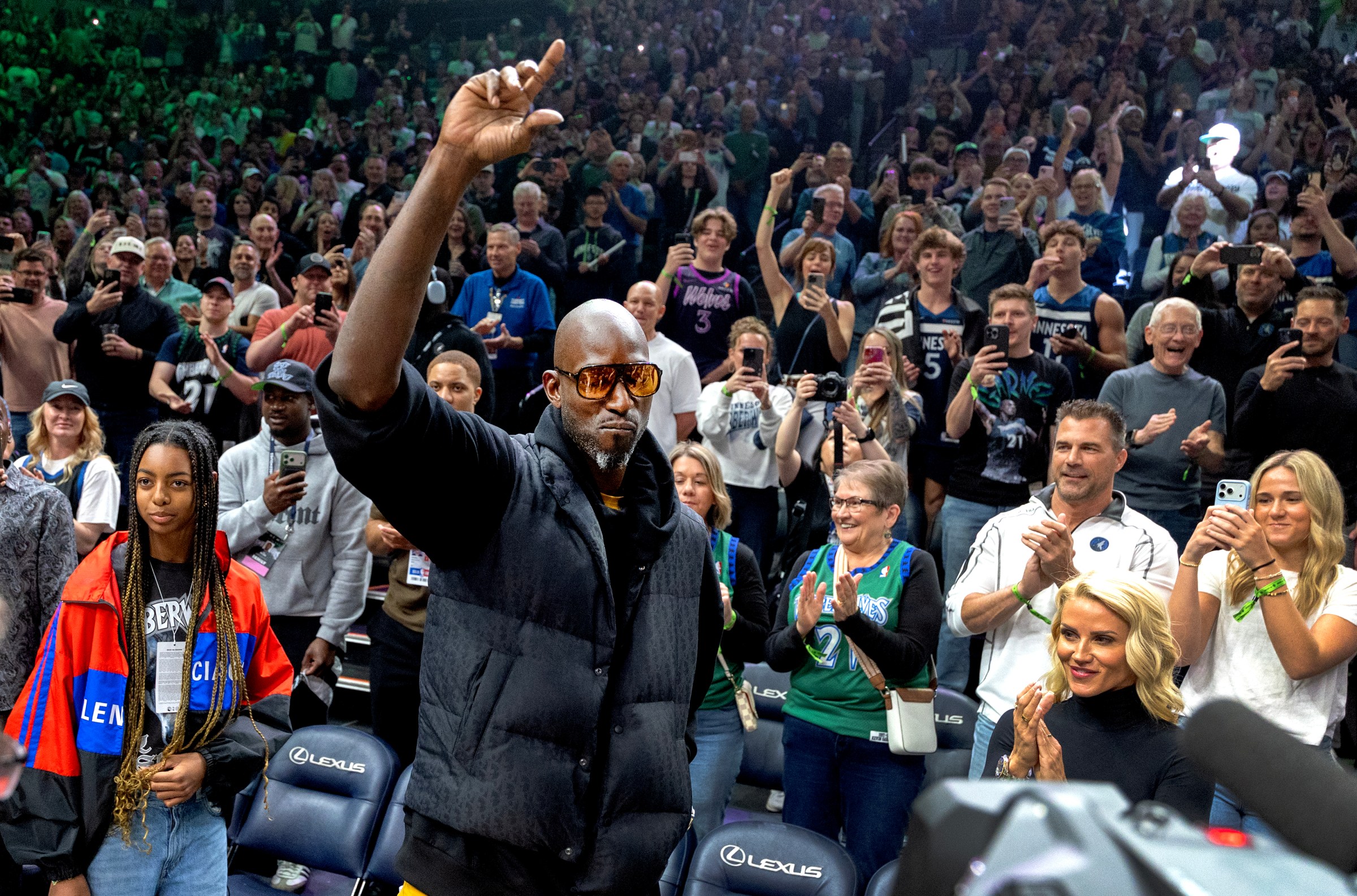 MINNEAPOLIS, MN. - APRIL 2026 Kevin Garnett acknowledges the crowd at Target Center in Minneapolis, Minn., on Sunday, April 12, 2026. Behind Garnett is his daughter Kavalli. The Hall of Fame forward and all-time franchise leader in nearly every major statistical category walked into the arena after player introductions, receiving a roar from the crowd and patting his heart with his hand. Garnett, who had a falling out with previous owner Glen Taylor after his career was over, reached an agreement last year with the team to serve as an ambassador. His No. 21 jersey will be retired at a later date. Minnesota Timberwolves vs. New Orleans Pelicans, final regular season game. (Photo by Carlos Gonzalez/The Minnesota Star Tribune via Getty Images)