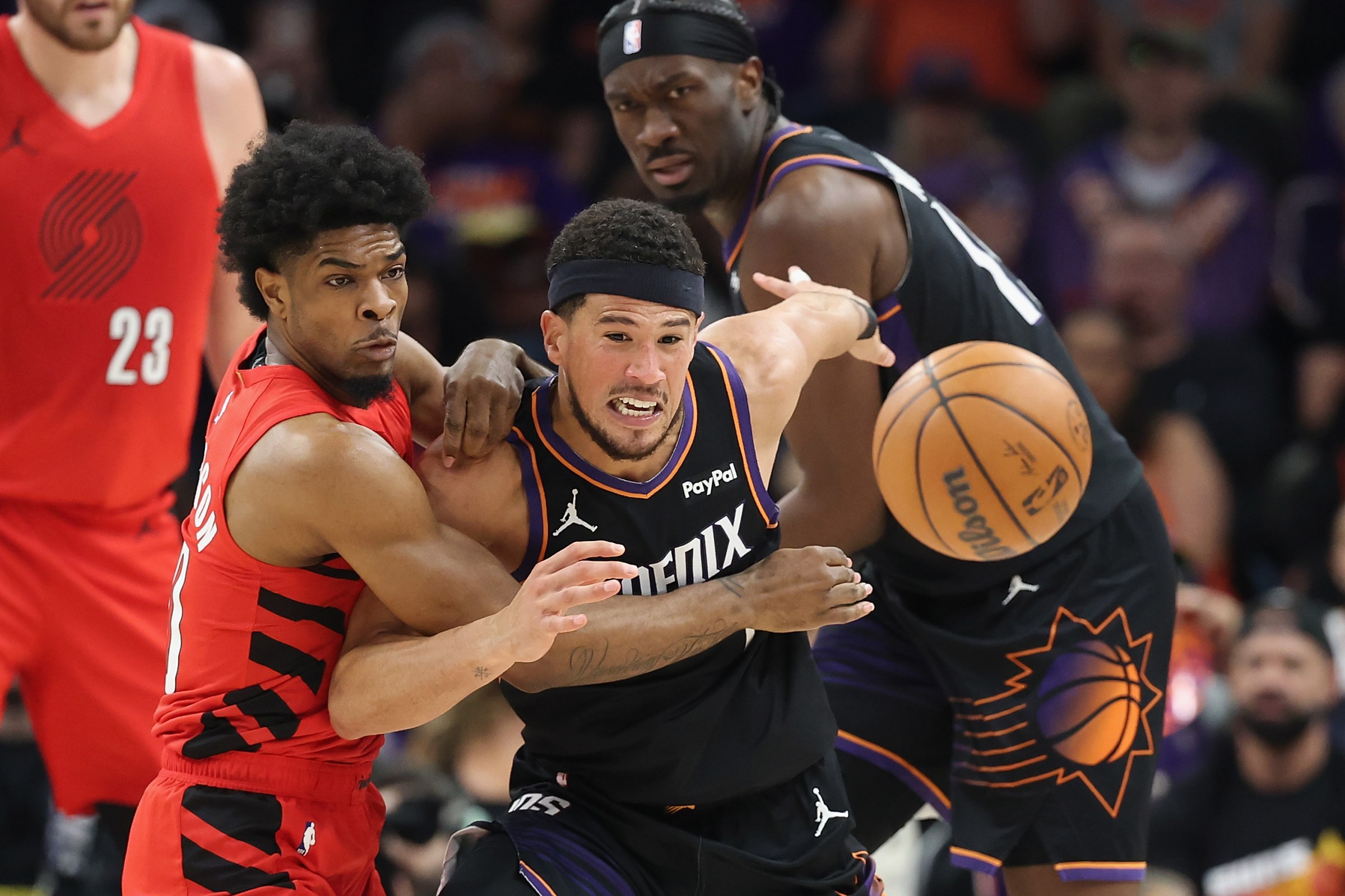 PHOENIX, ARIZONA - APRIL 14: Devin Booker #1 of the Phoenix Suns and Scoot Henderson #00 of the Portland Trail Blazers battle for a loose ball during the first half of an NBA play-in tournament game at Mortgage Matchup Center on April 14, 2026 in Phoenix, Arizona. NOTE TO USER: User expressly acknowledges and agrees that, by downloading and or using this photograph, user is consenting to the terms and conditions of the Getty Images License Agreement. (Photo by Christian Petersen/Getty Images)