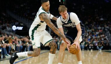 Milwaukee Bucks forward Kyle Kuzma (18) and Dallas Mavericks forward Cooper Flagg (32) reach for the ball during the first half of an NBA basketball game Tuesday, March 31, 2026, in Milwaukee.