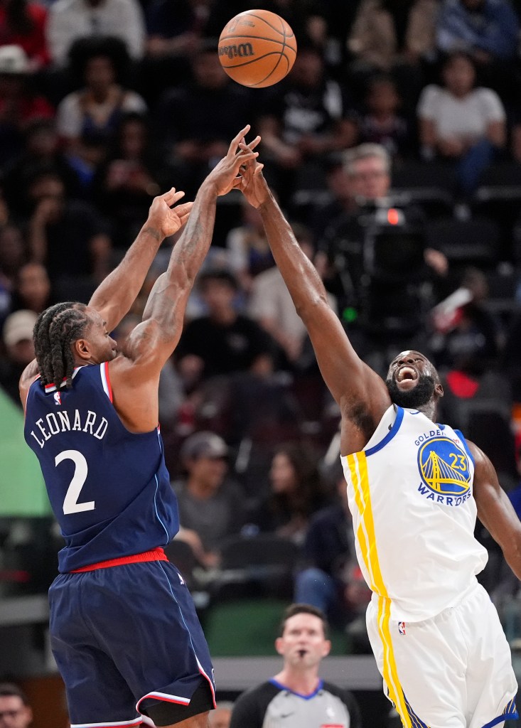 Kawhi Leonard shooting over Draymond Green during a basketball game.
