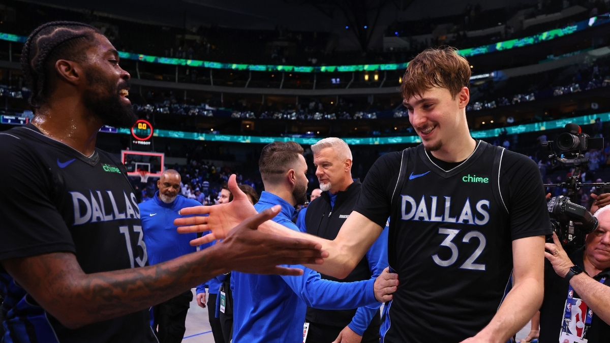 Naji Marshall #13 of the Dallas Mavericks greets Cooper Flagg #32 as they exit the court following a victory over the Los Angeles Lakers at American Airlines Center.